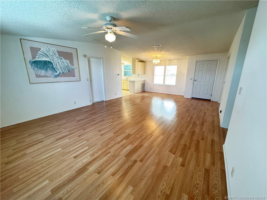 4236 Southeast Sweetwood Way Stuart, FL 34997 - Photo 6 of 50 a view of empty room with wooden floor and fan