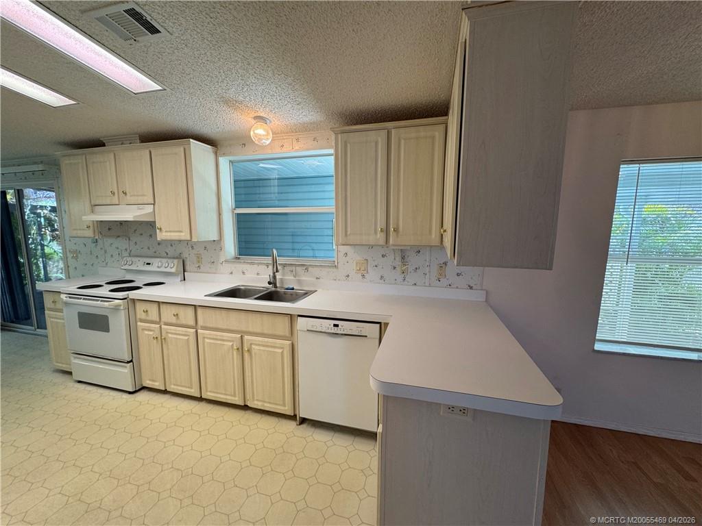 4236 Southeast Sweetwood Way Stuart, FL 34997 - Photo 10 of 50 a kitchen with granite countertop a sink stainless steel appliances and cabinets