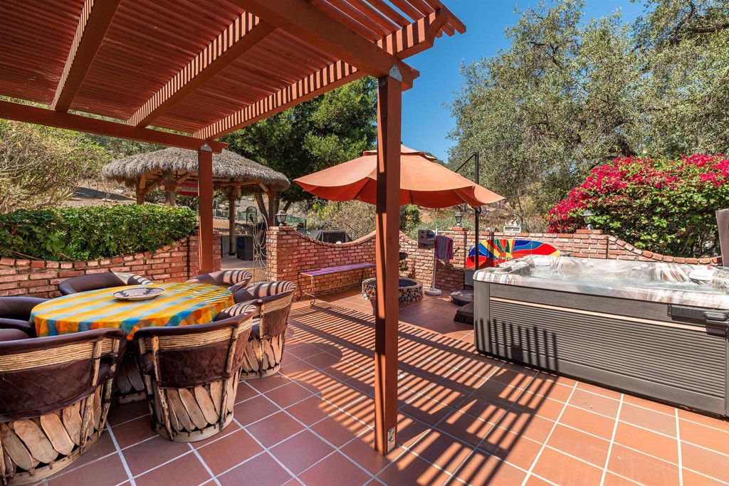 1168 Alpine Heights Road Alpine, CA 91901 - Photo 3 of 72 a view of a patio with table and chairs under an umbrella with a small yard