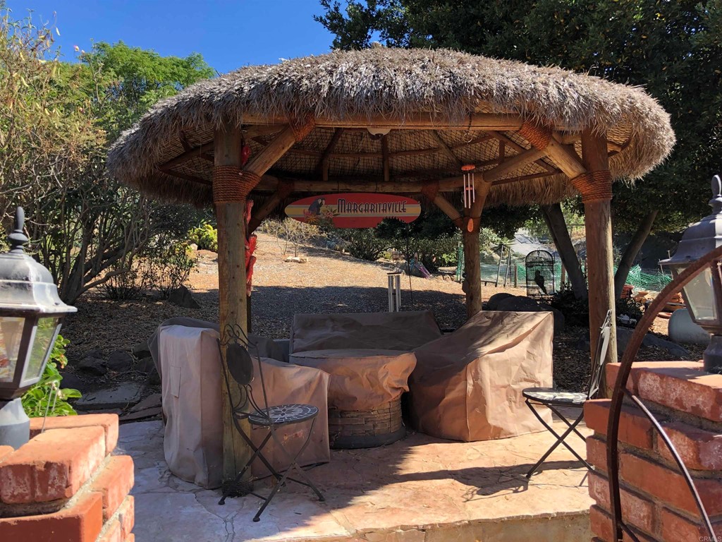 1168 Alpine Heights Road Alpine, CA 91901 - Photo 58 of 72 a view of a patio with table and chairs under an umbrella with a barbeque