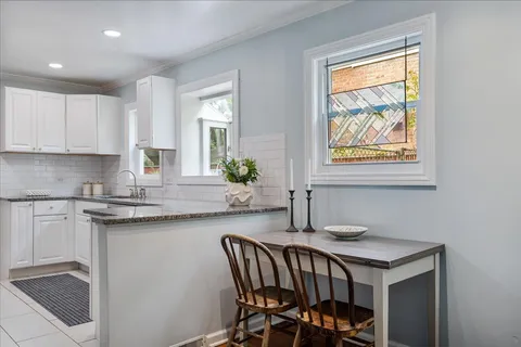 a kitchen with a table chairs sink and cabinets