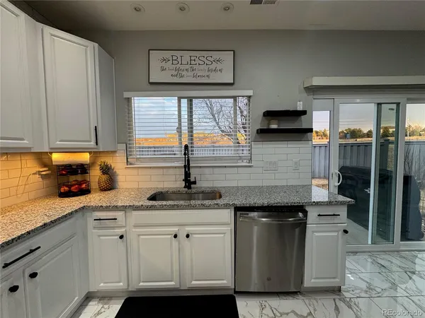 a kitchen with granite countertop a sink and a stove