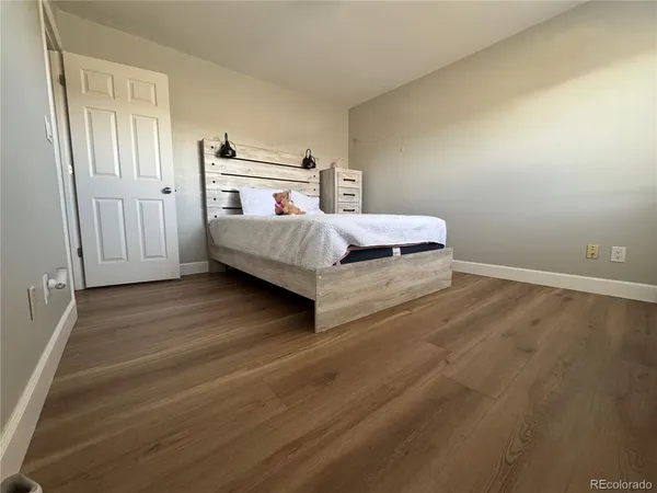 a bedroom with a bed and wooden floor