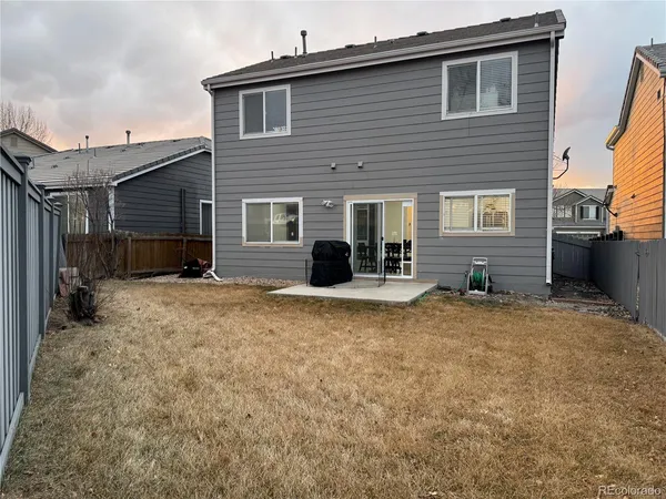 a view of a house with backyard and a barbeque