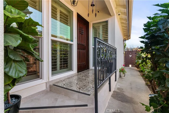 a view of a porch with a floor to ceiling window and potted plants