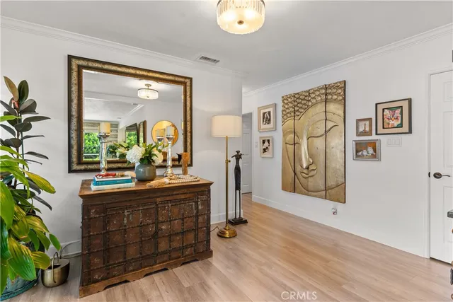a room with painting on the wall and a potted plant
