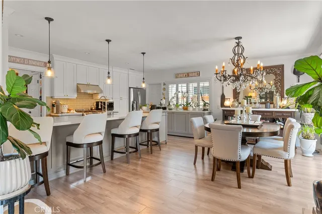a view of a dining room and livingroom with furniture wooden floor a chandelier