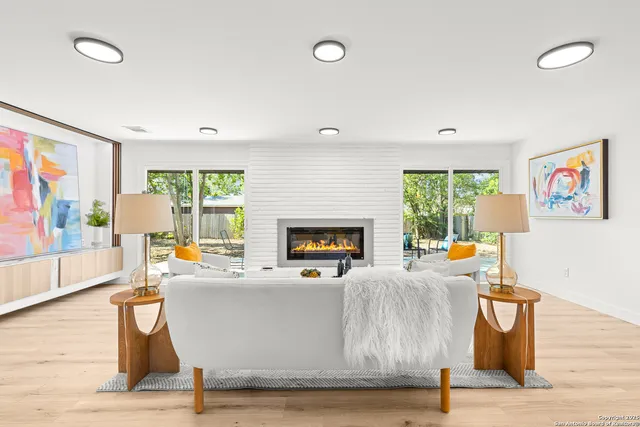 a living room with furniture a large window and a fireplace