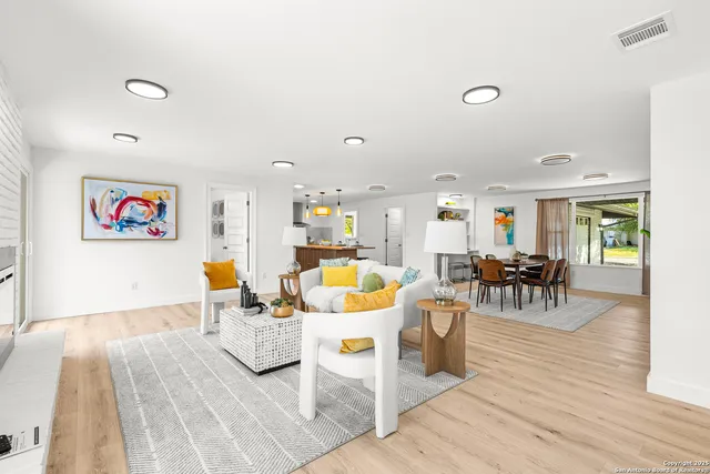 a living room with lots of chairs and wooden floor