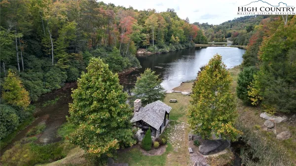 a view of a lake with a yard and wooden fence