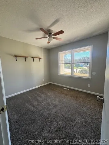 en empty room with windows and ceiling fan