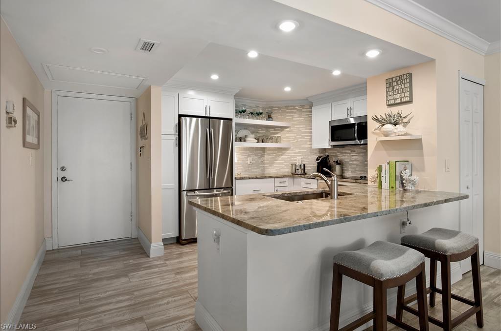 Undisclosed Address Naples, FL 34108 - Photo 3 of 14 a kitchen with stainless steel appliances granite countertop a sink refrigerator and cabinets