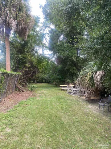 a view of backyard with swimming pool and seating space
