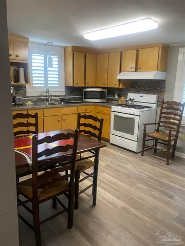 a kitchen with a stove a sink and a microwave