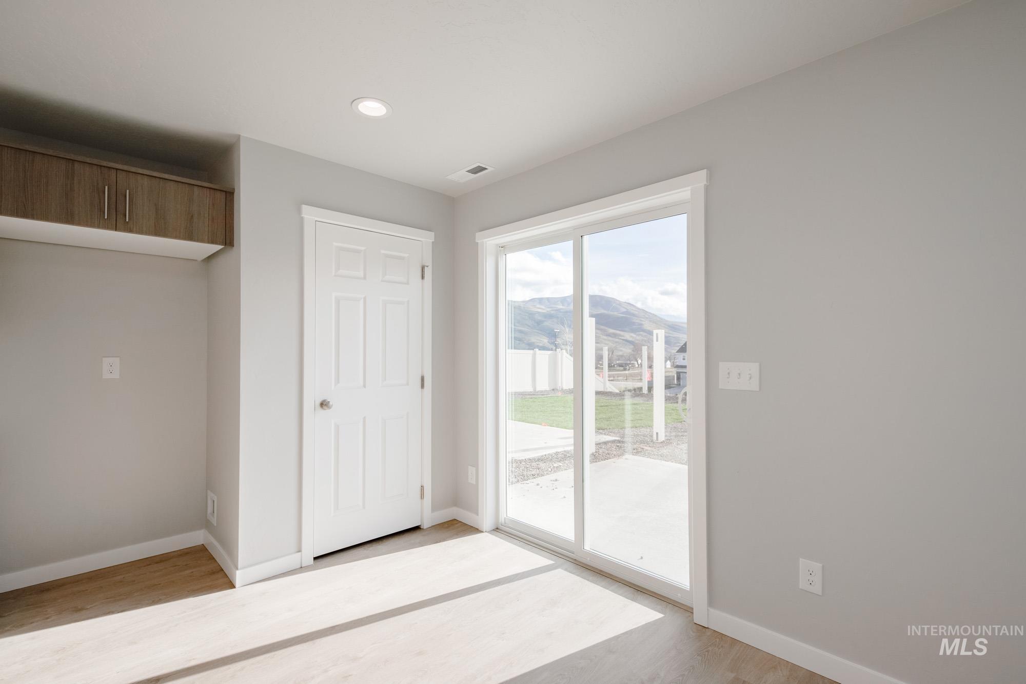 229 Moose Street Horseshoe Bend, ID 83629 - Photo 9 of 27 Unfurnished bedroom featuring access to outside, light wood-style flooring, a mountain view, and recessed lighting