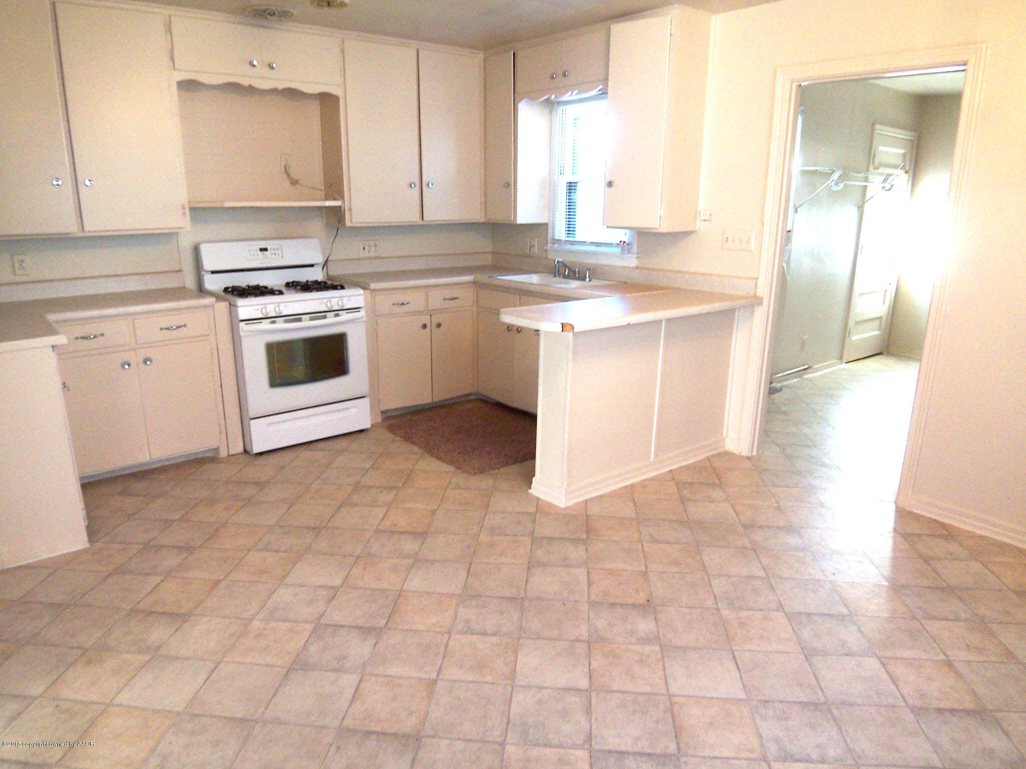 4124 Parker Street Amarillo, TX 79110 - Photo 3 of 12 a kitchen with a stove a sink and a refrigerator
