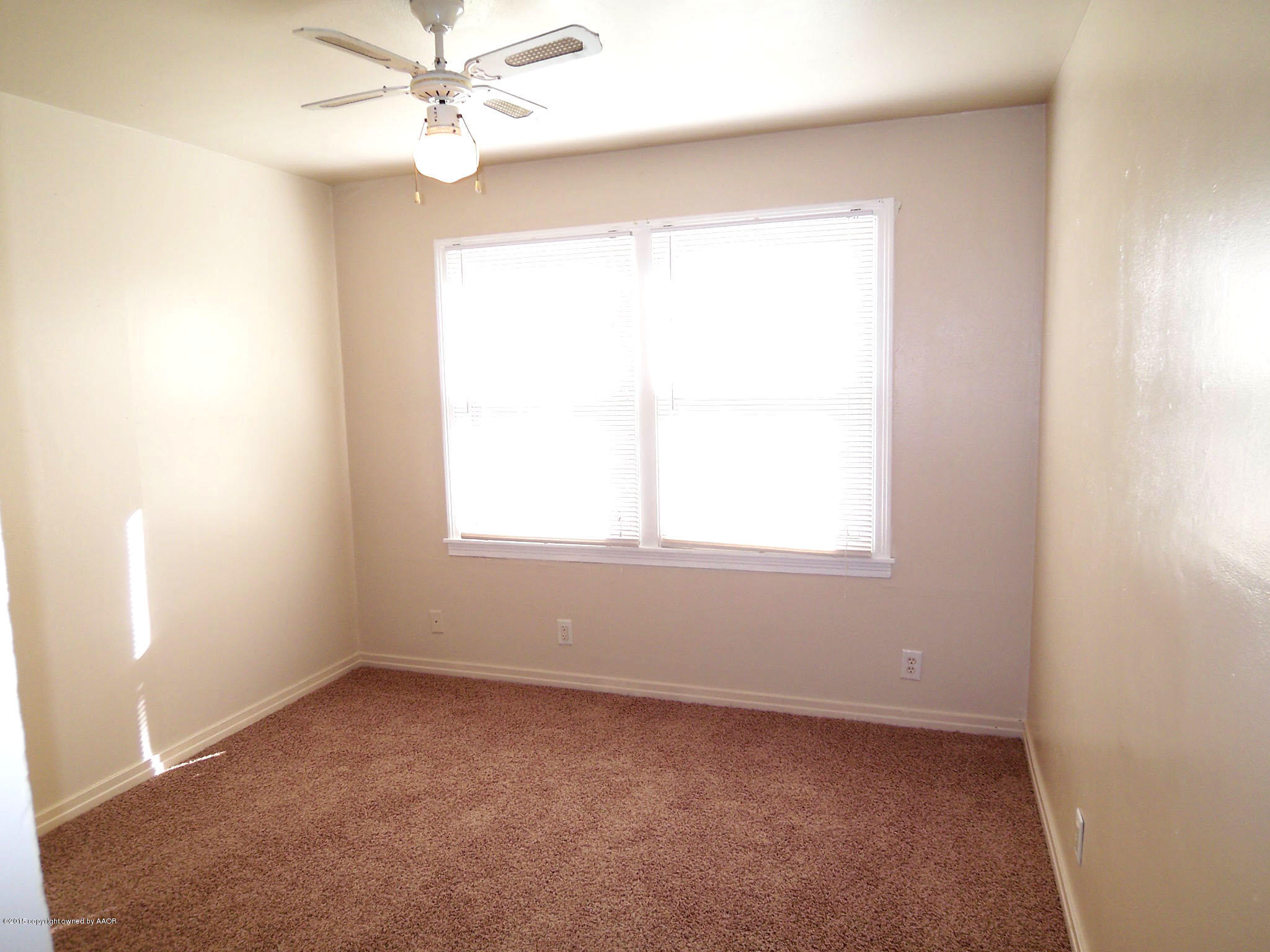 4124 Parker Street Amarillo, TX 79110 - Photo 5 of 12 an empty room with a window and a fan