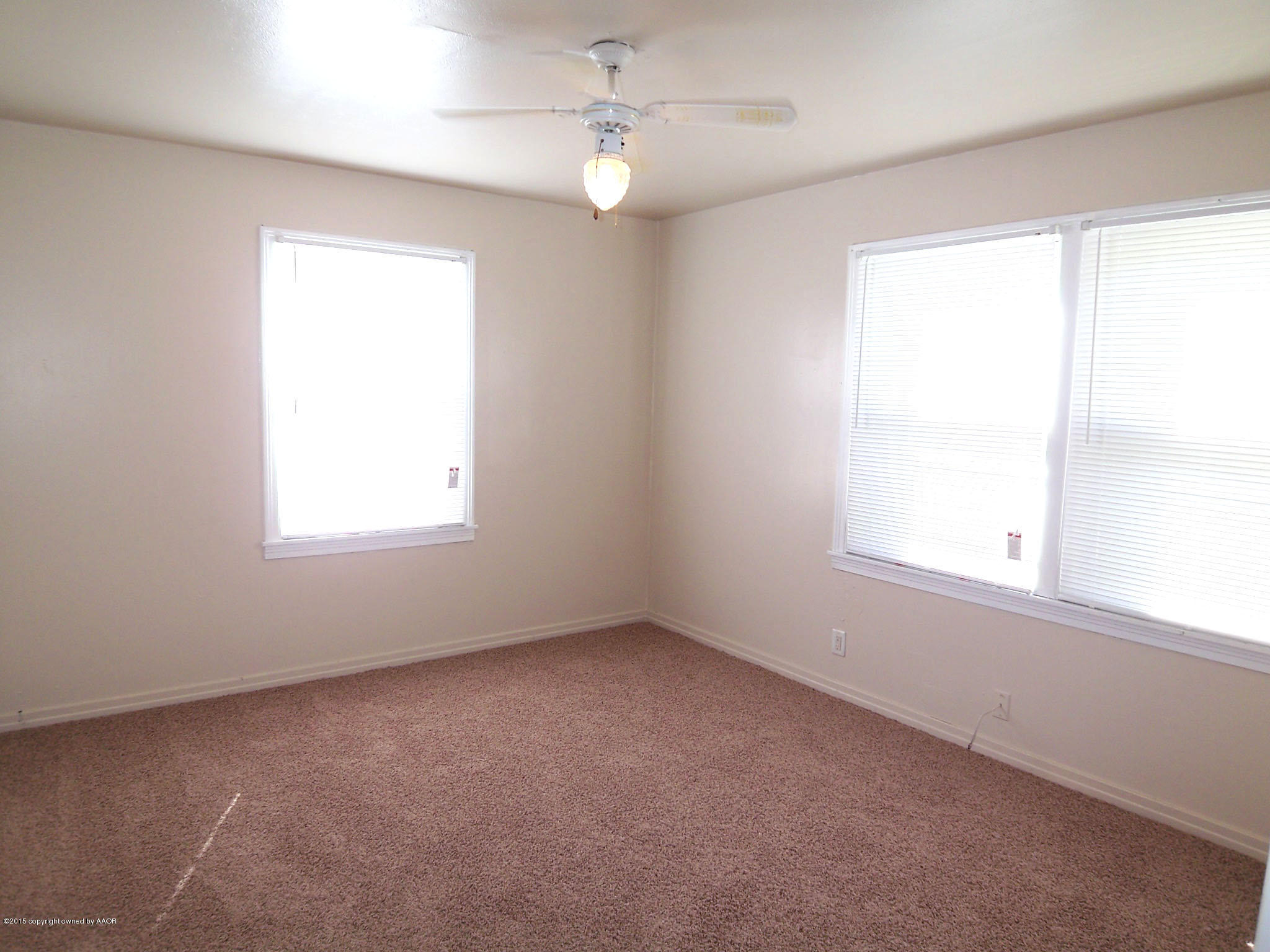4124 Parker Street Amarillo, TX 79110 - Photo 6 of 12 an empty room with a window and a fan