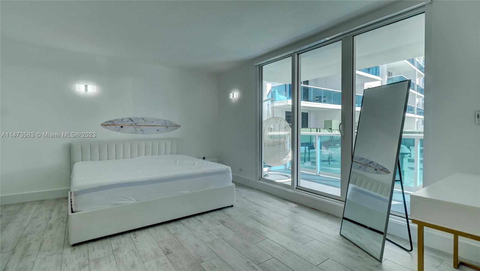 2301 Collins Avenue, Unit 321 Miami Beach, FL 33139 - Photo 12 of 33 a spacious bedroom with a large bed and a chandelier