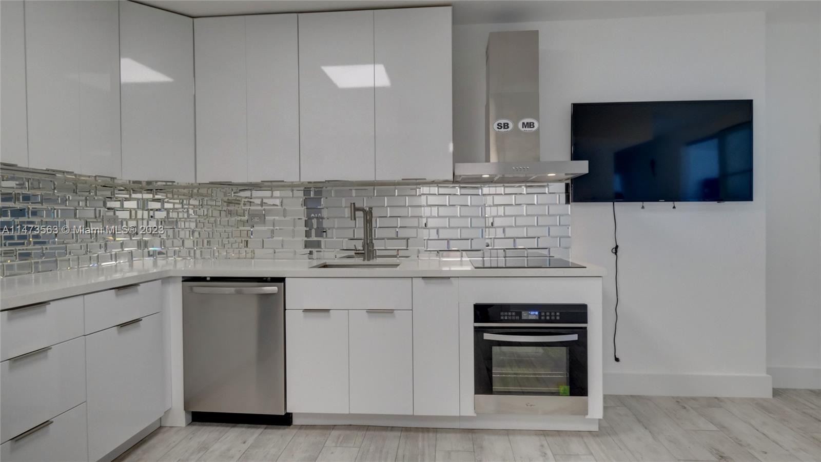 2301 Collins Avenue, Unit 321 Miami Beach, FL 33139 - Photo 18 of 33 a kitchen with stainless steel appliances granite countertop a stove and a microwave