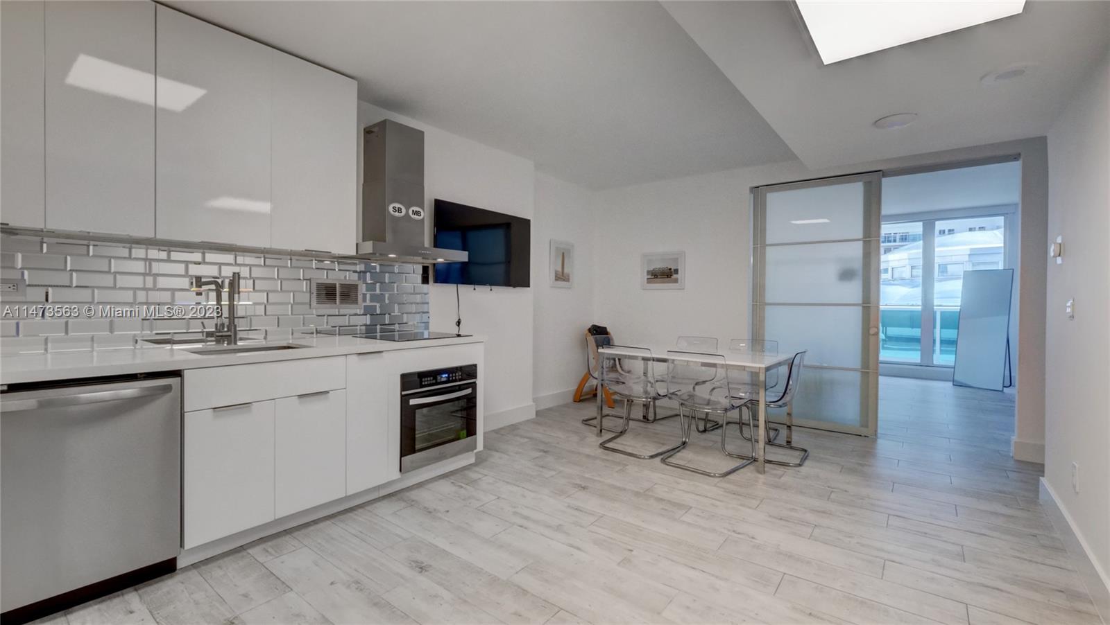 2301 Collins Avenue, Unit 321 Miami Beach, FL 33139 - Photo 2 of 33 a kitchen with stainless steel appliances kitchen island granite countertop a sink and cabinets