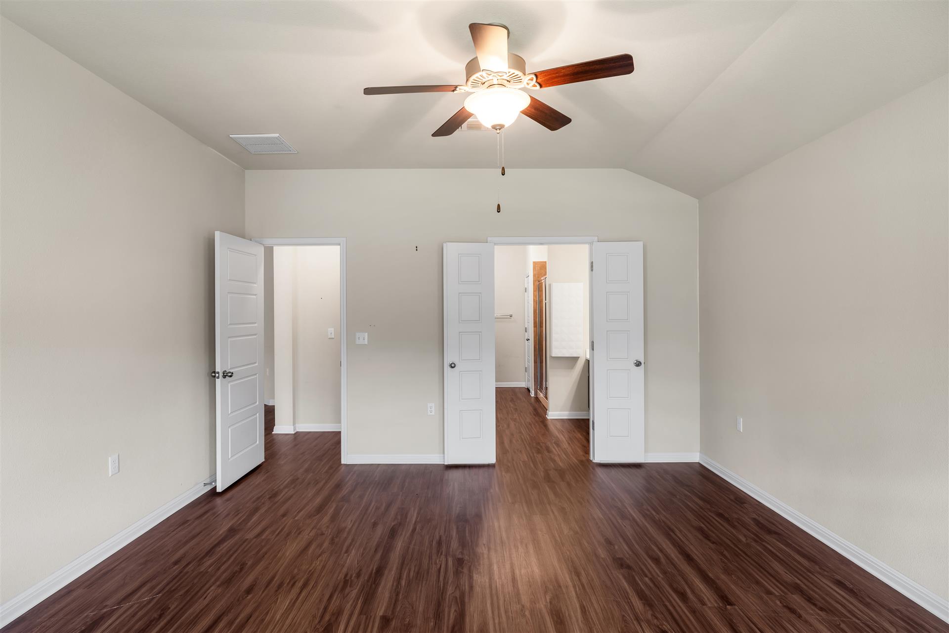 16512 Enamorado Road Manor, TX 78653 - Photo 26 of 31 Rich hardwood-style flooring and a vaulted ceiling create an inviting atmosphere in this versatile space.