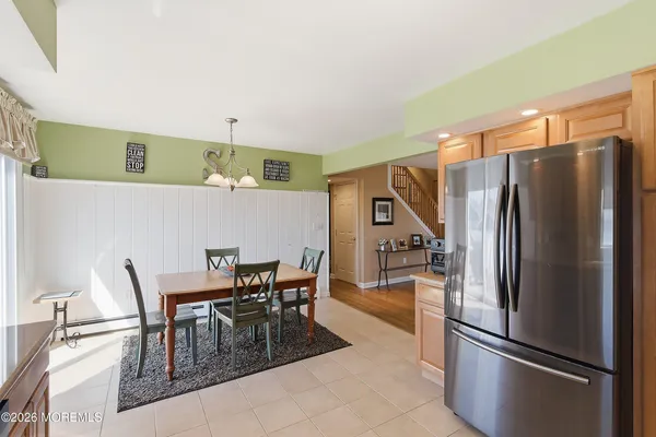 a kitchen with stainless steel appliances granite countertop a refrigerator and a dining table
