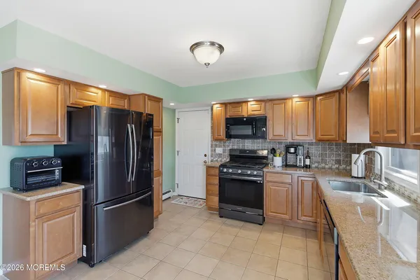 a kitchen with stainless steel appliances granite countertop a refrigerator stove top oven a sink and dishwasher