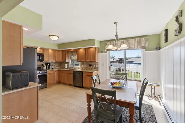 a kitchen with a dining table chairs stainless steel appliances and cabinets