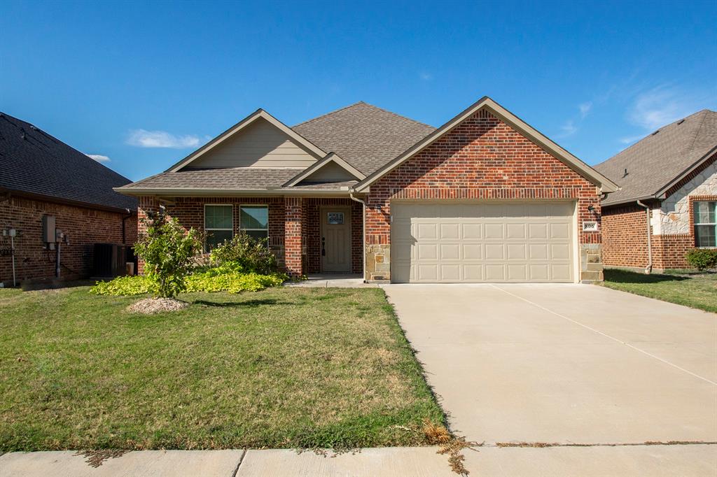 806 Ransom Way Greenville, TX 75402 - Photo 1 of 27 Red brick exterior with stone accents, attached garage, and a concrete driveway