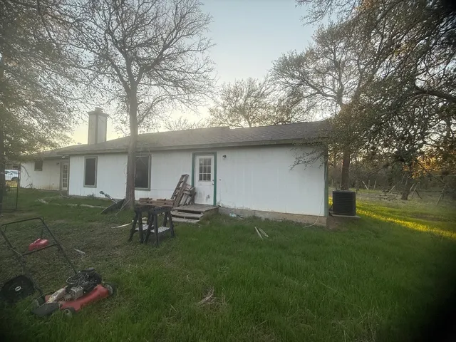 a view of a backyard with table and chairs and a barbeque with wooden fence