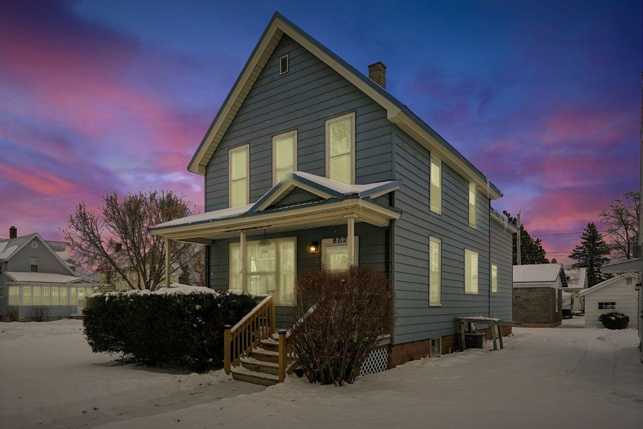 American foursquare style home with covered porch and a chimney