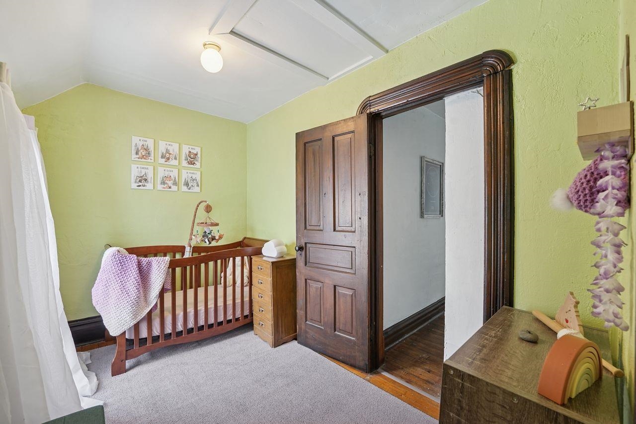 802 3rd Avenue East Ashland, WI 54806 - Photo 11 of 22 Bedroom with a crib and wood finished floors