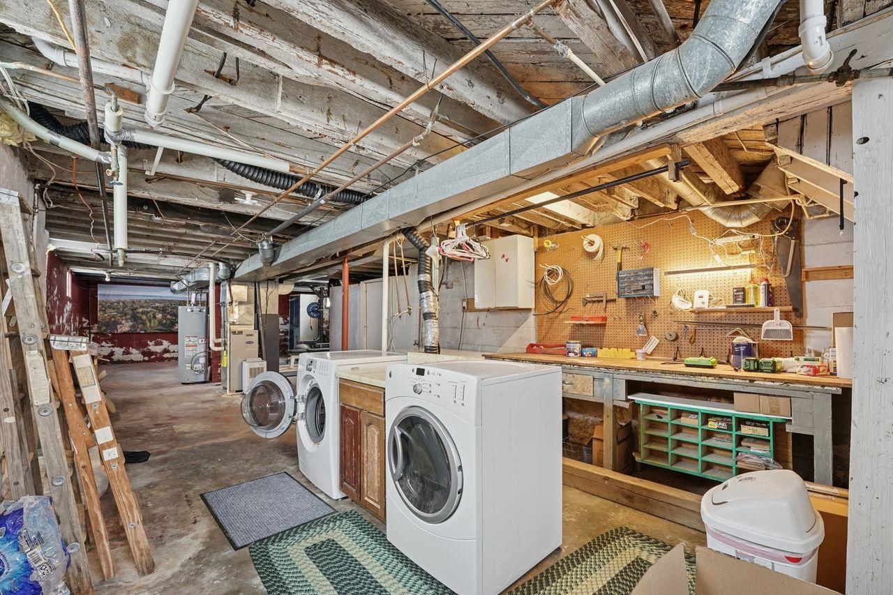 802 3rd Avenue East Ashland, WI 54806 - Photo 19 of 22 Washroom featuring unfinished concrete flooring, cabinet space, water heater, heating unit, and washing machine and clothes dryer