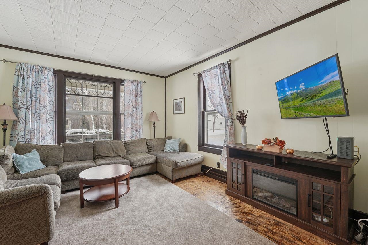 802 3rd Avenue East Ashland, WI 54806 - Photo 4 of 22 Living room featuring ornamental molding, healthy amount of natural light, and a glass covered fireplace