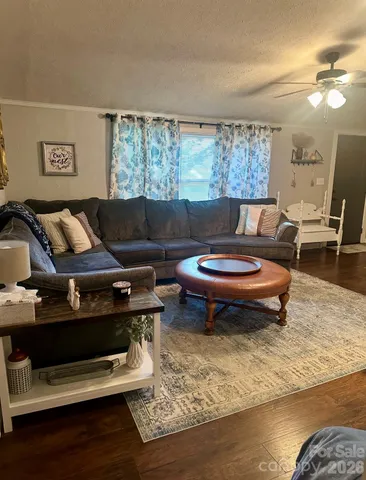 a living room with furniture a rug and a floor to ceiling window