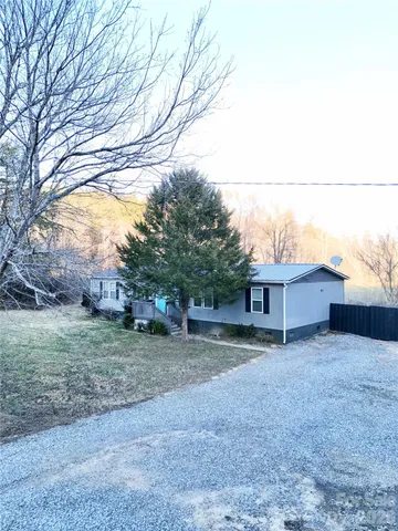 a view of a house with a large tree and a yard
