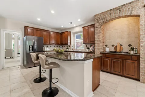 a kitchen with granite countertop a sink and a refrigerator