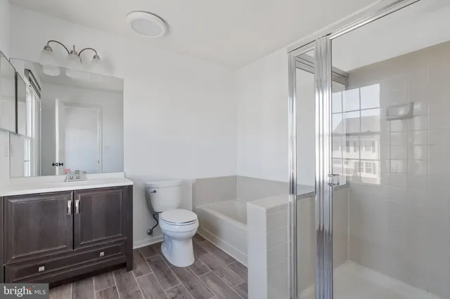 a bathroom with a granite countertop sink mirror vanity and toilet