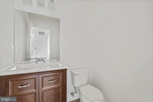 a bathroom with a granite countertop toilet sink and mirror