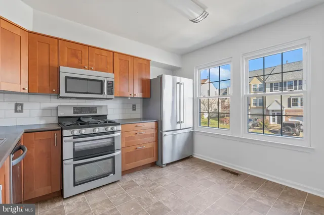 a kitchen with stainless steel appliances granite countertop a refrigerator stove top oven and sink