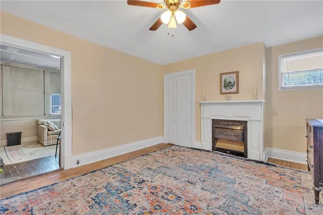 a view of an empty room with window and a fireplace