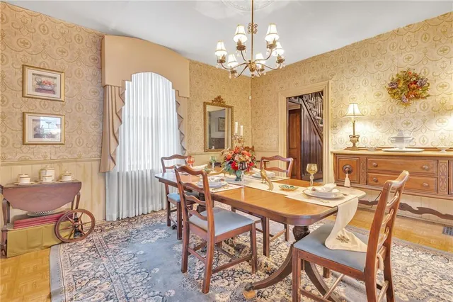 a view of a dining room with furniture a chandelier and wooden floor