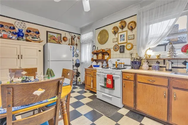 a room with stainless steel appliances kitchen island granite countertop a refrigerator and a sink