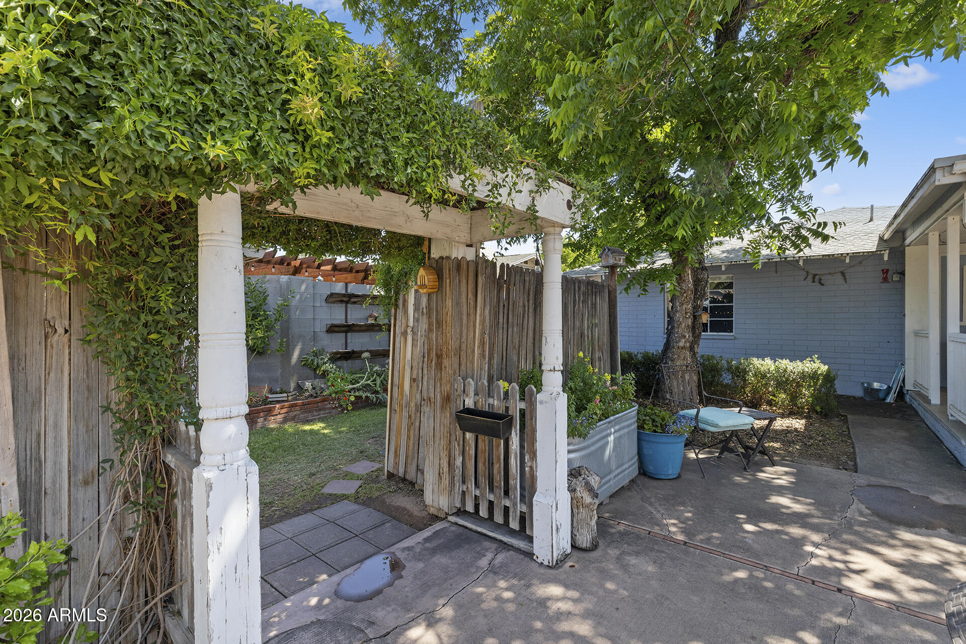 5228 North 15th Street Phoenix, AZ 85014 - Photo 54 of 96 a backyard of a house with table and chairs a barbeque with wooden fence and plants