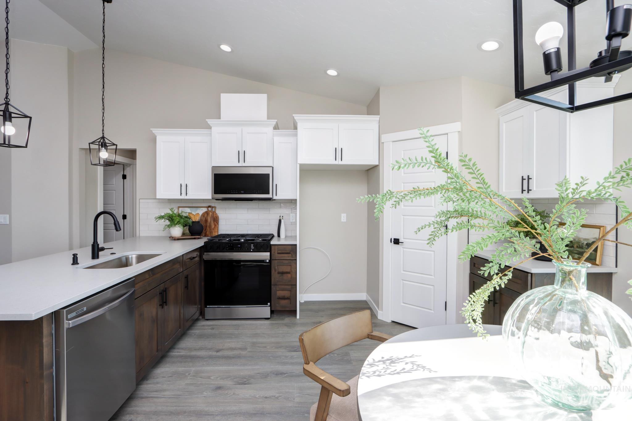 848 North 5th Street Nyssa, OR 97913 - Photo 6 of 49 Modern kitchen featuring two-tone cabinetry, stainless steel appliances, a white subway tile backsplash, and wood-finish flooring