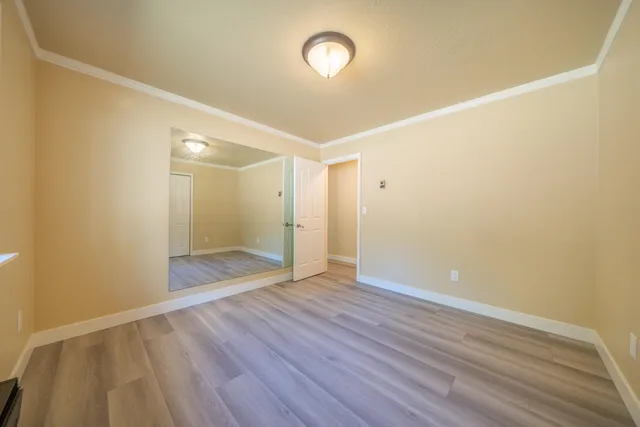 a bedroom with a large bed a chandelier and a window