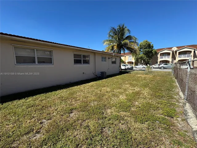 a backyard of a house with table and chairs
