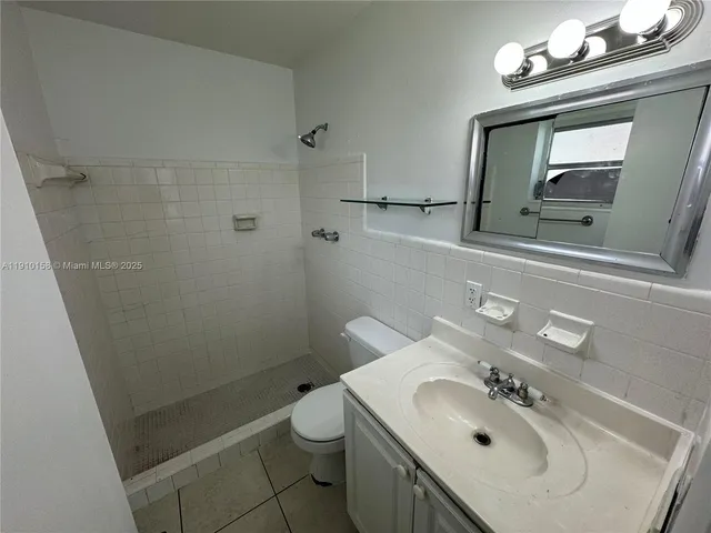 a bathroom with a sink vanity granite toilet and a mirror