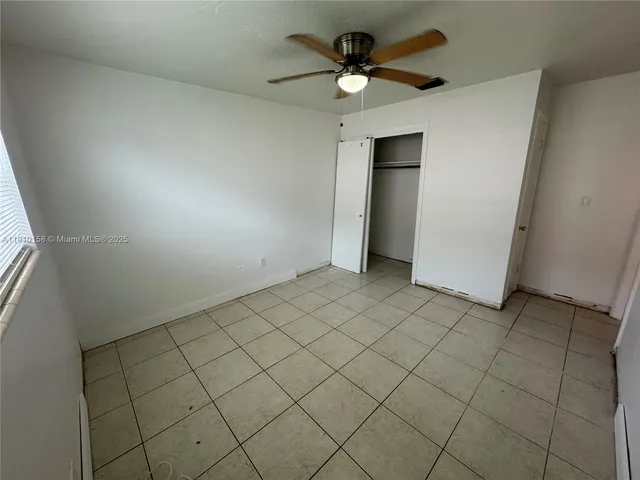 an empty room with a ceiling fan and a bathtub